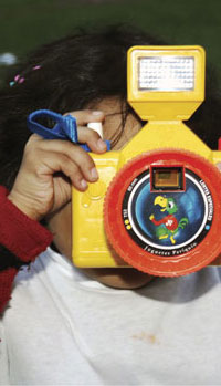 Partial Photo of child holding a toy camera to her face